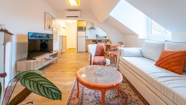 Un apartamento moderno con zona de estar tipo loft, cocina y comedor.