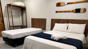 A hotel room with two beds, a wooden bench, and two wooden paddles on the wall. - Morada do Sol Suítes (Arraial do Cabo)