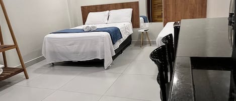 A hotel room with a bed, a desk, and a chair.