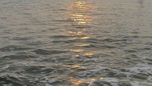 A beach scene with waves and a sunset.