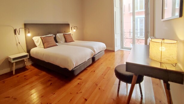 Ein Schlafzimmer mit zwei Betten, einem Schreibtisch und einem Stuhl.