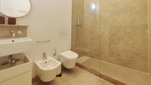 Ein modernes Badezimmer mit integriertem Bidet, Toilette und Duschkabine.