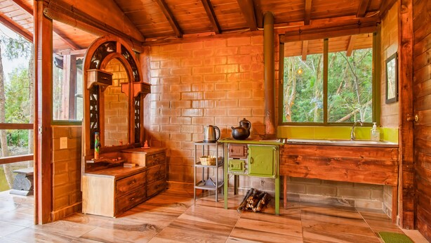 A rustic cabin bathroom with wooden walls, a green sink, and a large window overlooking trees. - Glamping Experience Savieza (Nemocon)