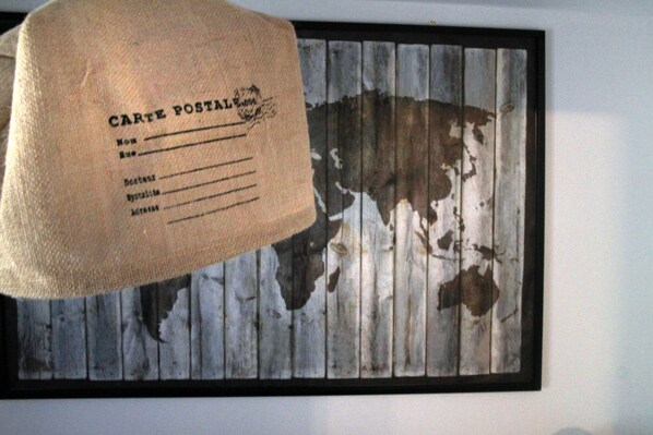 A framed map with a vintage postcard hanging above it.