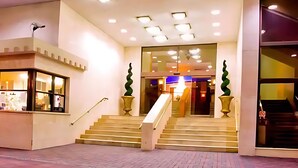 Ein Hotel mit Eingangsbereich, Treppe, Rezeption und Topfpflanzen.