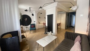 Een moderne woonkamer met een bank, een salontafel en een eethoek met een stoel en een tafel.