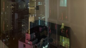 A modern building with a prominent tower featuring illuminated rings. - Soho Suites KLCC by Inam Suites (Kuala Lumpur)