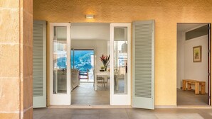 A spacious entryway with a view to the outside, a dining area with a table and chairs, and a small seating area with a bench. - H2916 Holiday apartment Guillem in Cala San Vicente (Cala Sant Vicenç)