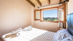 A bedroom with a bed, a window with a view of trees, and a wooden ceiling. - H2923 Finca Capo with pool for 6 persons near Sa Pobla (Sa Pobla)