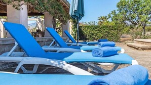 A row of blue lounge chairs with towels, a pergola, and a view of the landscape. - H2924 Finca Catalina for 4 persons with pool near Pollenca (Pollenca)
