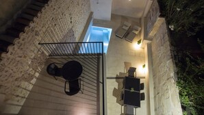 Una terrazza panoramica con piscina, posti a sedere all'aperto e una scala.