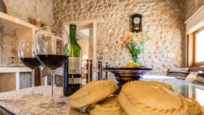 Un tavolo con un piatto di pasticcini, una bottiglia di vino e bicchieri di vino rosso.