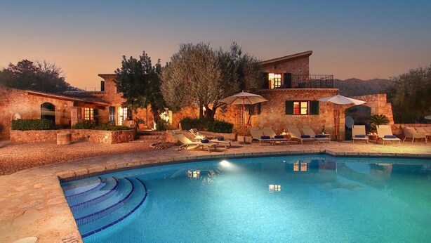 A poolside area with a clear blue pool, stone walls, and lounge chairs. - H2910 Finca Bennassar Pollensa (Pollenca)