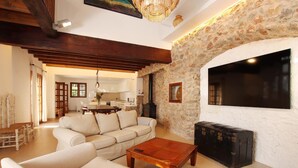 A cozy living room with a stone wall, a wooden coffee table, and a sofa. - H2910 Finca Bennassar Pollensa (Pollenca)