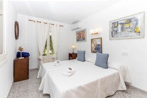 A hotel room with two beds, a small table with a lamp, and artwork on the walls. - H2914 Finca Gran Voramar (Cala Sant Vicenç)
