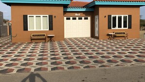 A two-story house with a tiled roof, a garage, and a patterned tile floor. - Very clean1 bedroom sleeps 4. Close to shopping and beach. Neighborhood setting  (Tanki Flip)