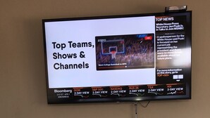 A television mounted on a wall displaying a sports channel. Below the TV, there is a white cabinet with glass doors. - Very clean1 bedroom sleeps 4. Close to shopping and beach. Neighborhood setting  (Tanki Flip)