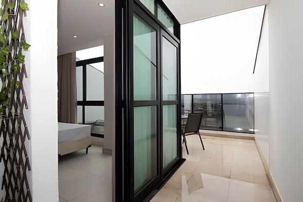 Ein modernes Interieur mit einer großen Glasdoor, einem Sofa und einem Essbereich.