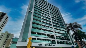 Een hoog hotel met een modern ontwerp, met een opvallend 'Athos Bulcão' bord aan de voet.