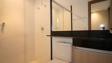 A modern bathroom with a shower, toilet, and sink.