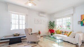 A modern living room with a sofa, armchair, glass coffee table, and a decorative rug. - CALLE COMPETA 11 (LAS LAGUNAS DE MIJAS,)