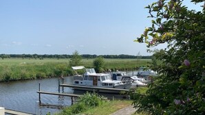 Un canal où est amarrée une péniche à un quai en bois.