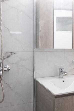 A bathroom with a shower, a sink, and a mirror. - Superb Family Apt In The Center Of Athens (Athens)