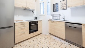 Eine moderne Küche mit Edelstahlgeräten, Holzschränken und einem Fleckenboden.