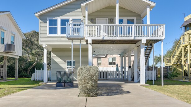 A two-story house with a balcony, a front porch, and a staircase leading to the second floor. - < 1 Mi to Beach! Poolside Retreat in Galveston (Galveston)