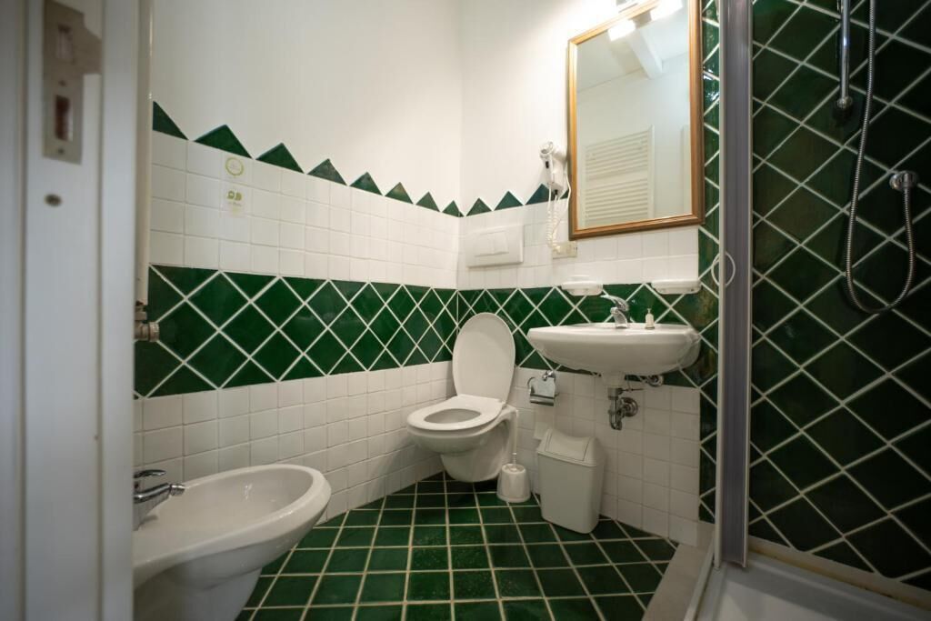 Une salle de bain équipée de toilettes, d’un bidet et d’un lavabo.