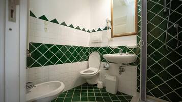 Une salle de bain équipée de toilettes, d’un bidet et d’un lavabo.