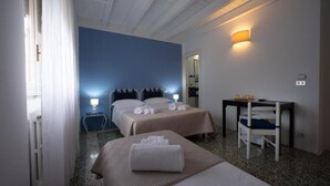 Una habitación de hotel con dos camas, un escritorio y una silla.