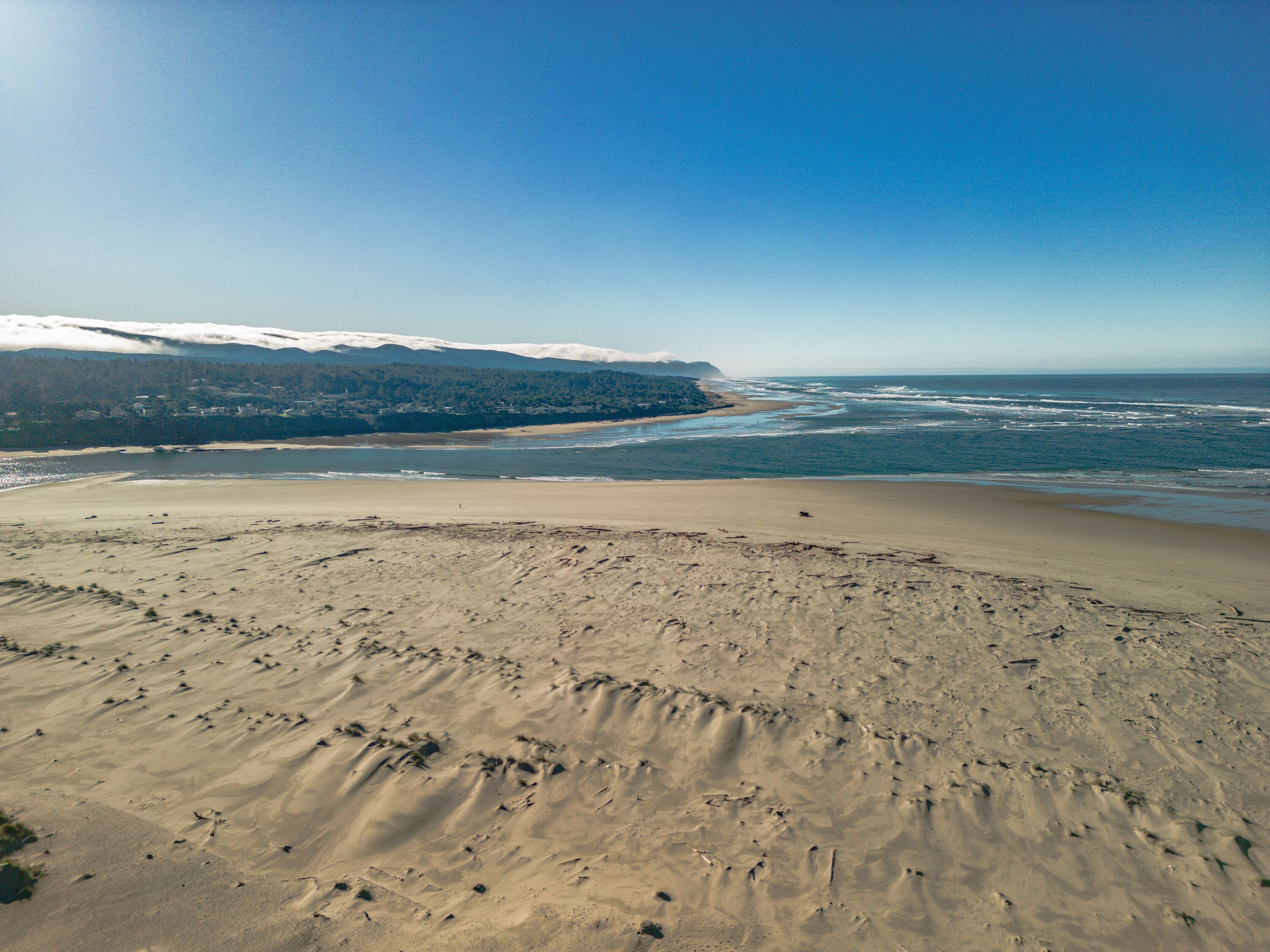 A beach with a clear view of the ocean and distant mountains.