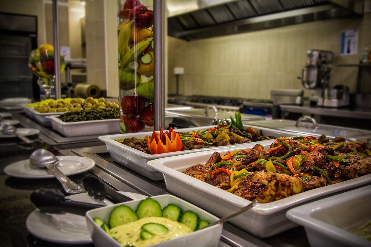 A buffet with various dishes including grilled meats, vegetables, and salads.