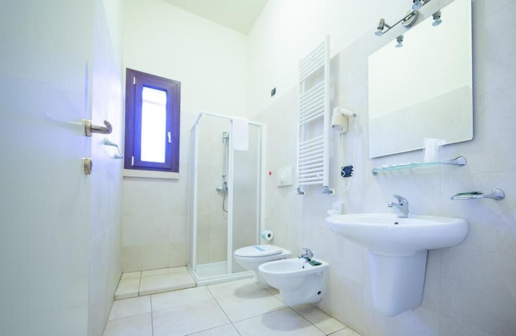 Un baño con ducha, inodoro, bidé, lavabo y espejo.