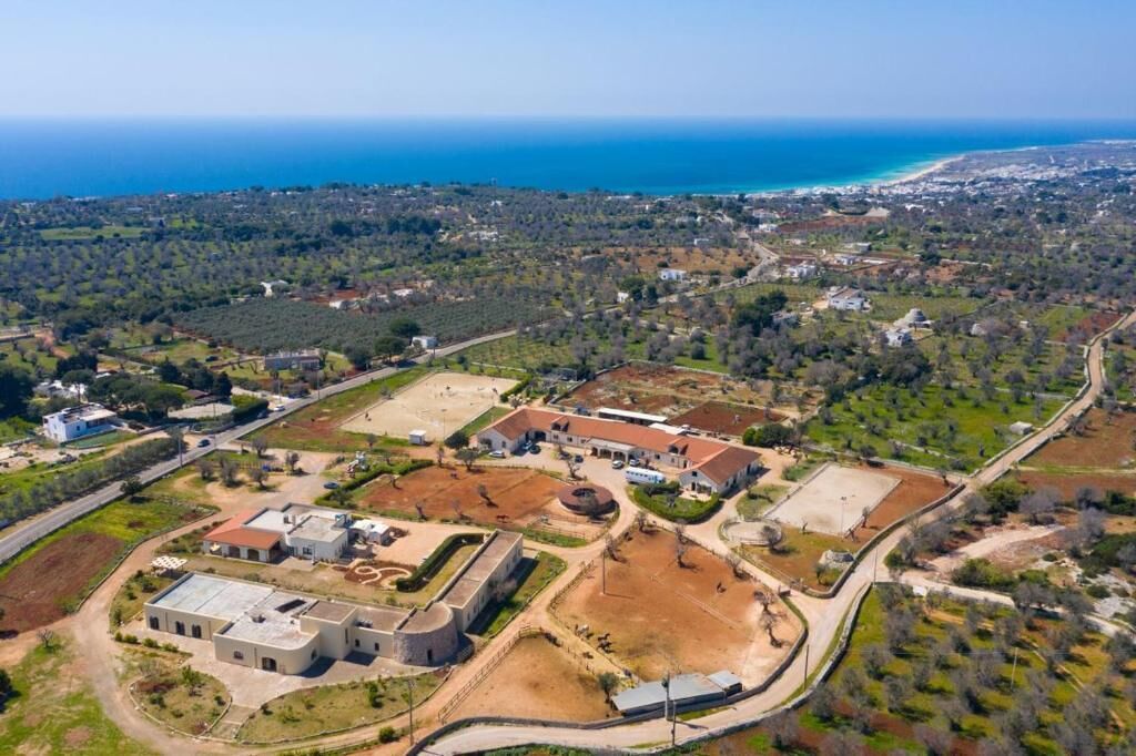 An aerial view of a coastal area with buildings, roads, and a beach.