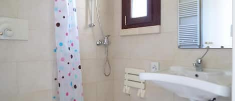 Un baño con inodoro, ducha y lavamanos.
