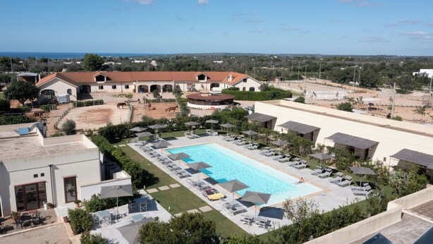 A resort with a swimming pool, sun loungers, and a view of the sea. - Delle Rose Hotel & Restaurant (Morciano di Leuca)