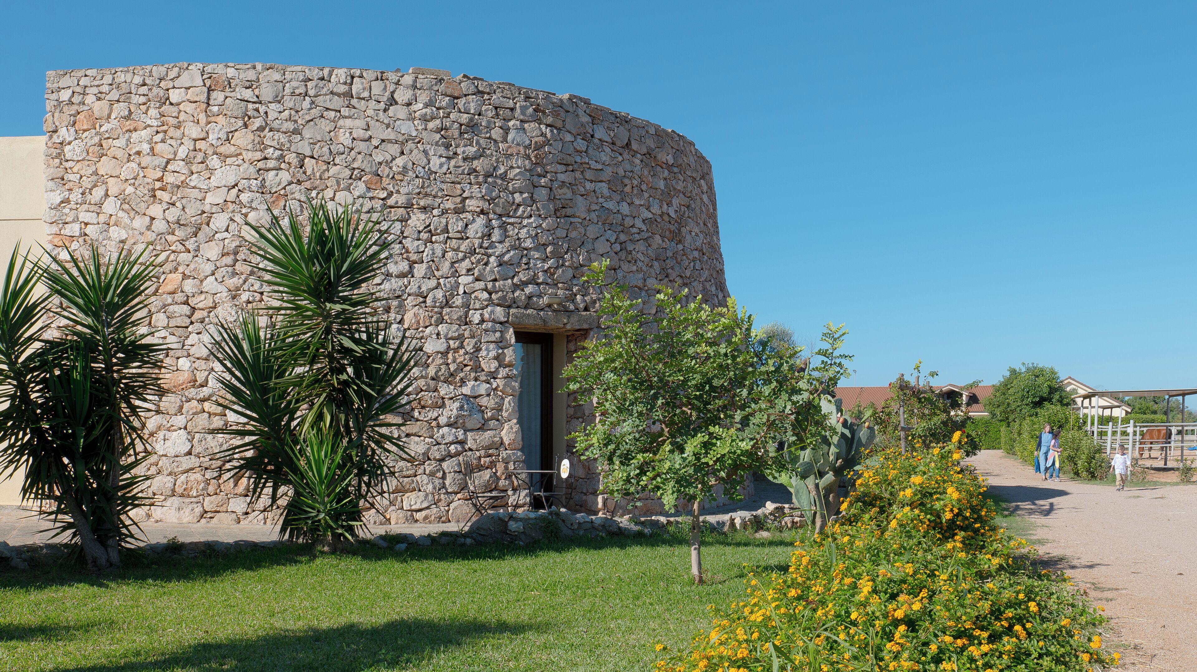 A stone building with a circular structure, a door, and a small window.