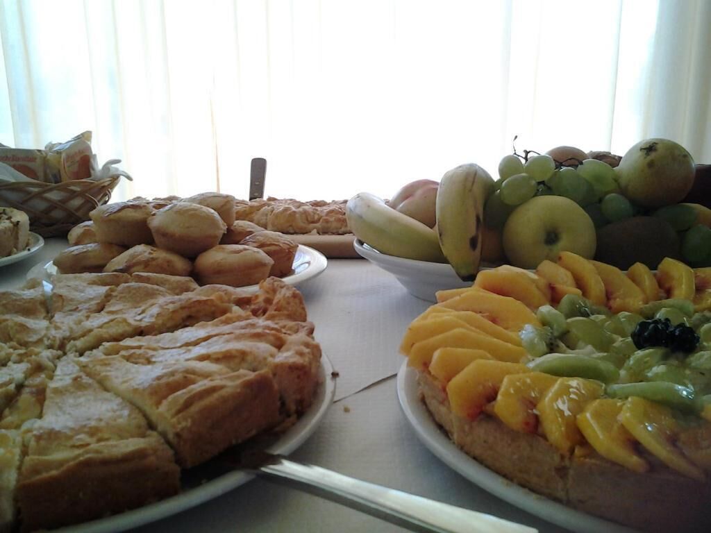 A table with various food items including pastries, fruits, and a dessert.
