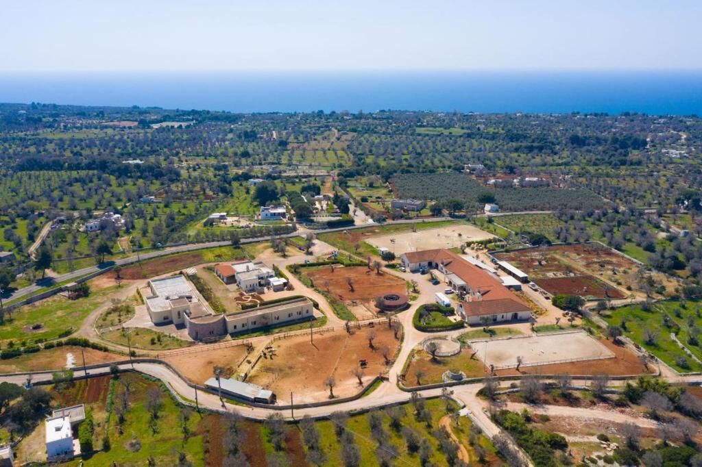An aerial view of a large, organized property with multiple buildings, roads, and green spaces.