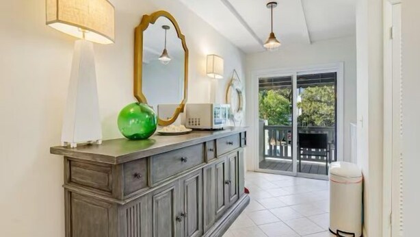 A modern bathroom with a vanity, a mirror, and a green vase. - The Olive Shell- condo steps to the beach (St Simons Island)