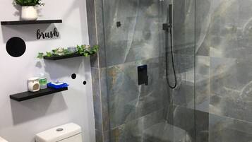 Chuveiro, toalhas de banho, sabonete, shampoo