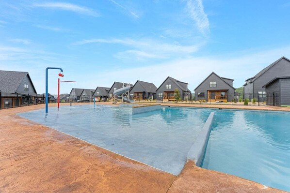 A residential area with multiple houses, a swimming pool, and a playground.