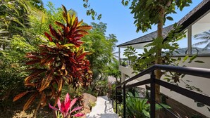 A staircase leading to a building surrounded by lush greenery and tropical plants. - Suan Kuchamudee (Koh Samui)