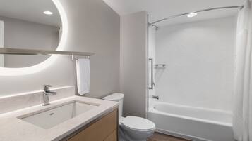 A modern bathroom with a rectangular sink, a toilet, and a glass-enclosed shower.