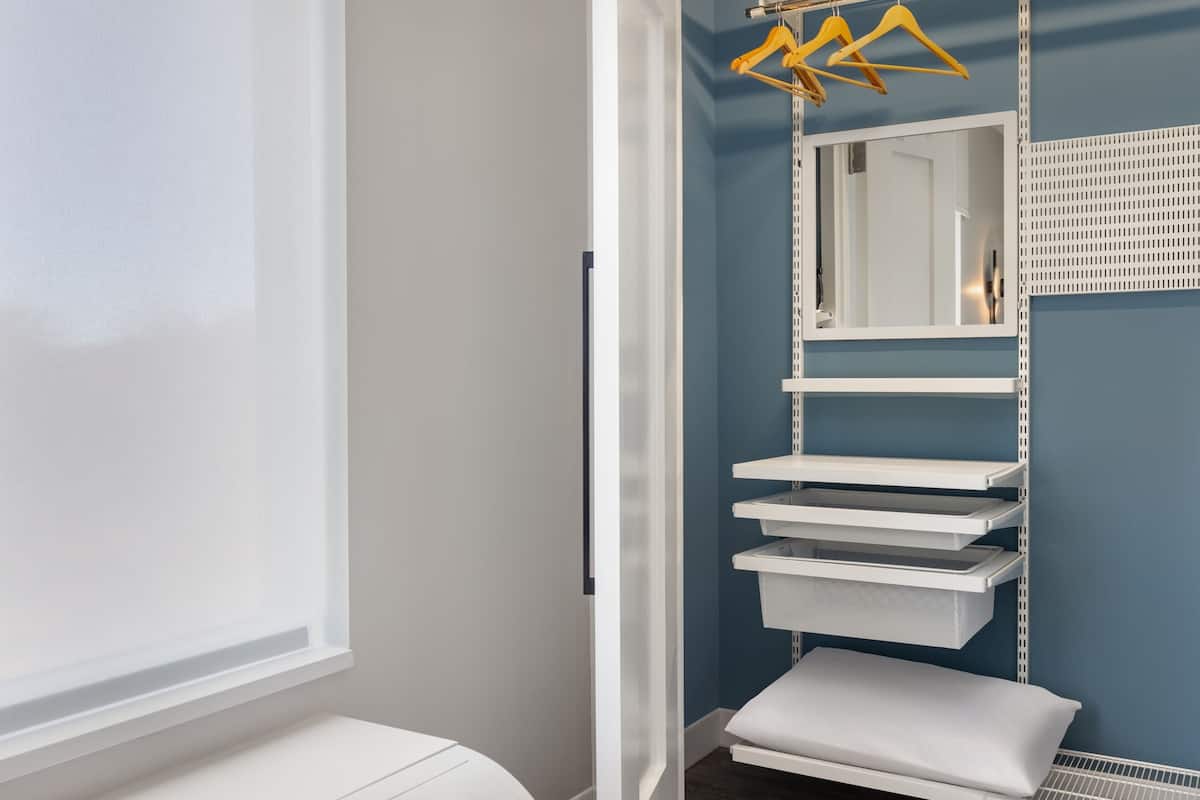 A bathroom with a white sink, a mirror, and a towel rack.