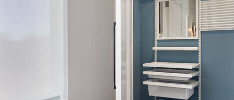 Une salle de bain avec un lavabo blanc, un miroir et un porte-serviettes.