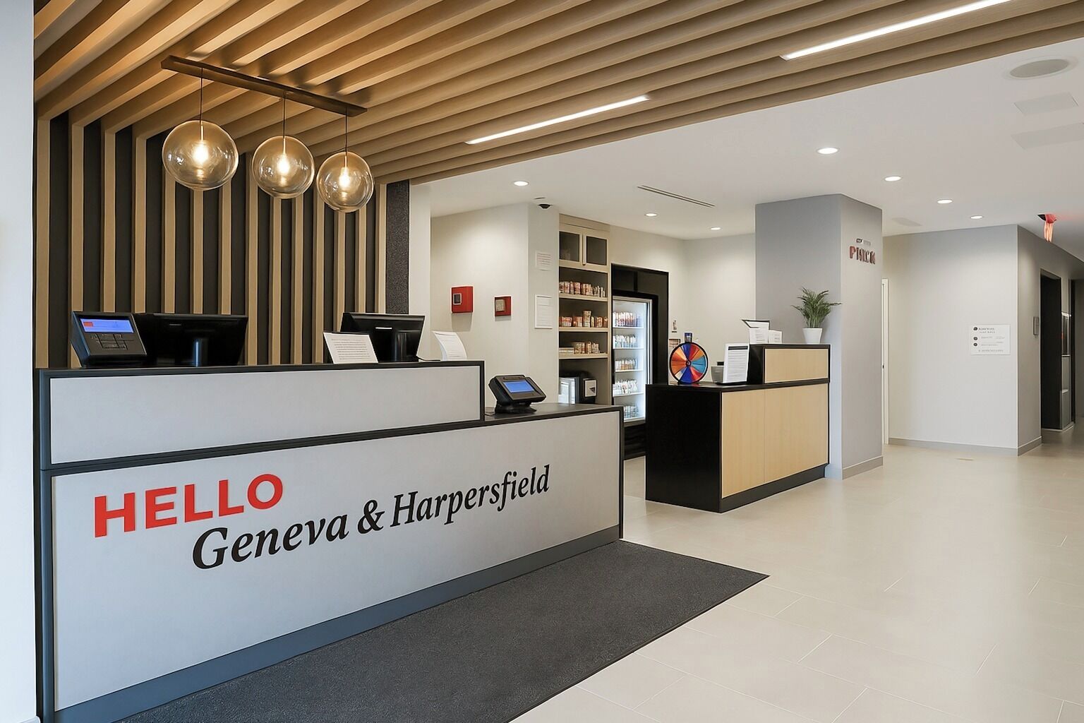 En receptionsdisk med et skilt, der siger 'HELLO Geneva & Harpersfield', et moderne interiør med trælameller i loftet, og et receptionsområde med en disk og en plante.
