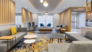 Eine moderne Hotelhalle mit Sofas, Tischen und einer Rezeption.